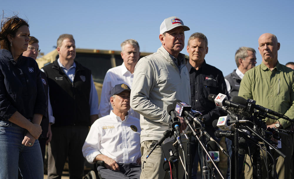 Texas Gov. Greg Abbott, seated center, listens as Georgia Gov. Brian Kemp, center, speaks during a news conference along the Rio Grande to discuss Operation Lone Star and border concerns, Sunday, Feb. 4, 2024, in Eagle Pass, Texas.