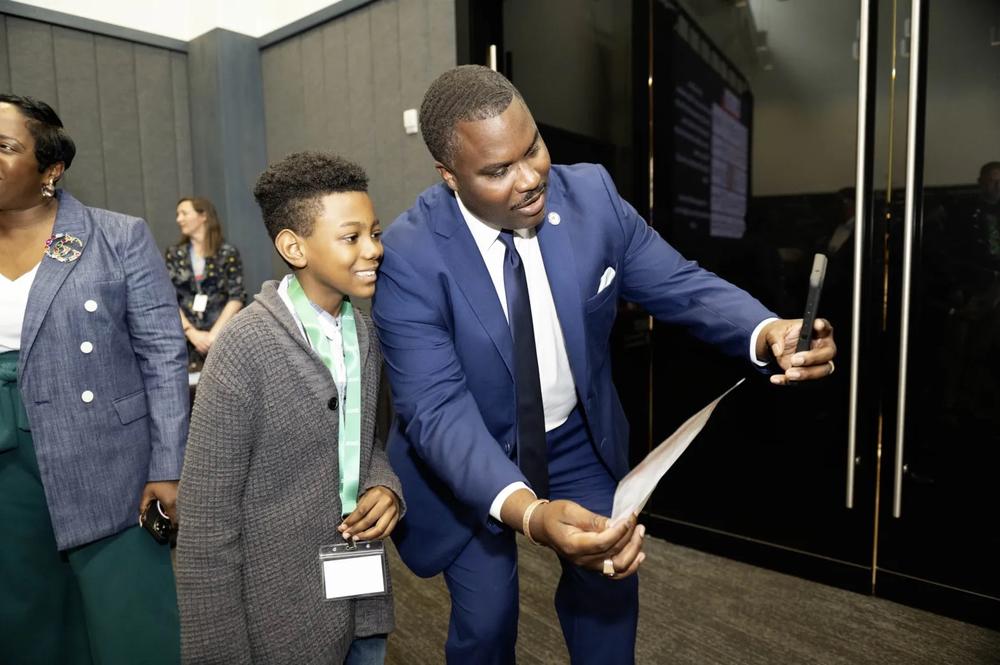 A young student taking a picture with an Atlanta community leader.
