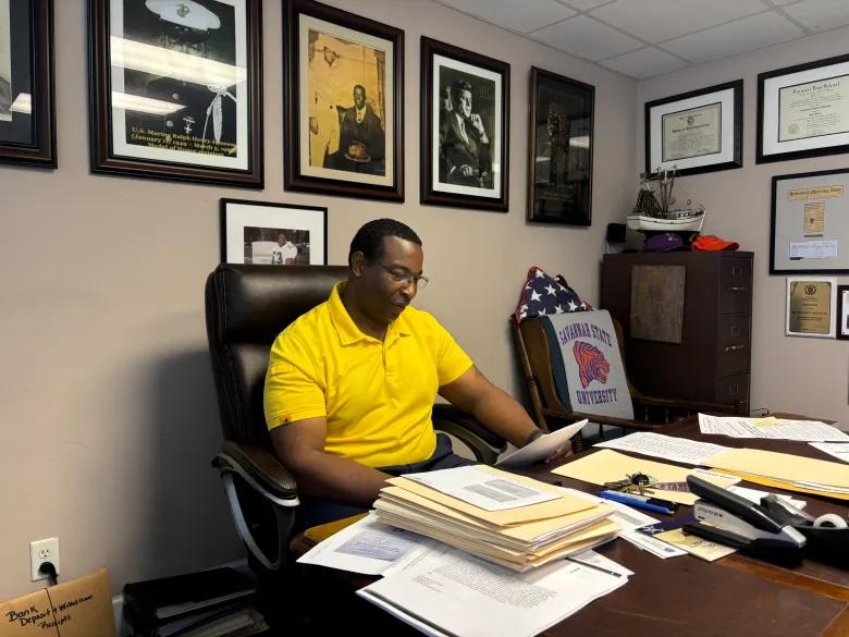 Middleton speaking with The Current in his office. He has framed photos of his legal and personal heroes: former U.S. President John F. Kennedy, Rev. Martin Luther King Jr., and his uncle, Ralph Johnson, who earned the Medal of Honor.  Credit: Jake Shore/The Current