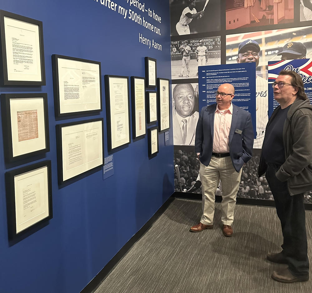 Paul Crater of the Atlanta History Center shows Chuck Reece a collection of letters written to Hank Aaron by Black leaders in Atlanta encouraging him to come to the city with the Braves