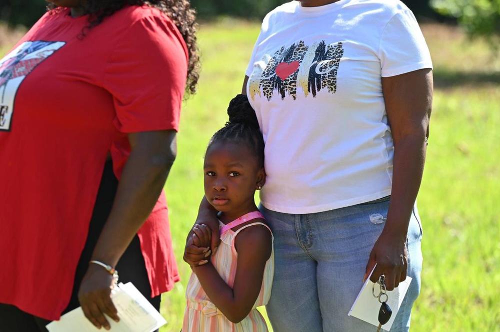 Giniyah Quinn, 4, stands with her grandmother and future homeowner Renita Blackwell at the Macon Area Habitat for Humanity ground blessing on Tuesday, May 28, 2024 in Macon, Georgia. Macon Area Habitat for Humanity held the ground blessing at a plot of land off in Lynmore Estates where three future homes will be built.