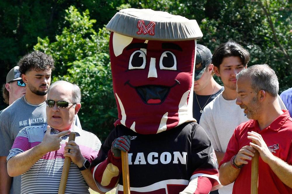 Vineville United Methodist Church pastor Jimmy Asbell (left) points at the Macon Bacon mascot Kevin during the Macon Area Habitat for Humanity ground blessing on Tuesday, May 28, 2024, in Macon, Georgia. The Macon Bacon are one of four sponsors for the Habitat for Humanity houses in Lynmore Estates.