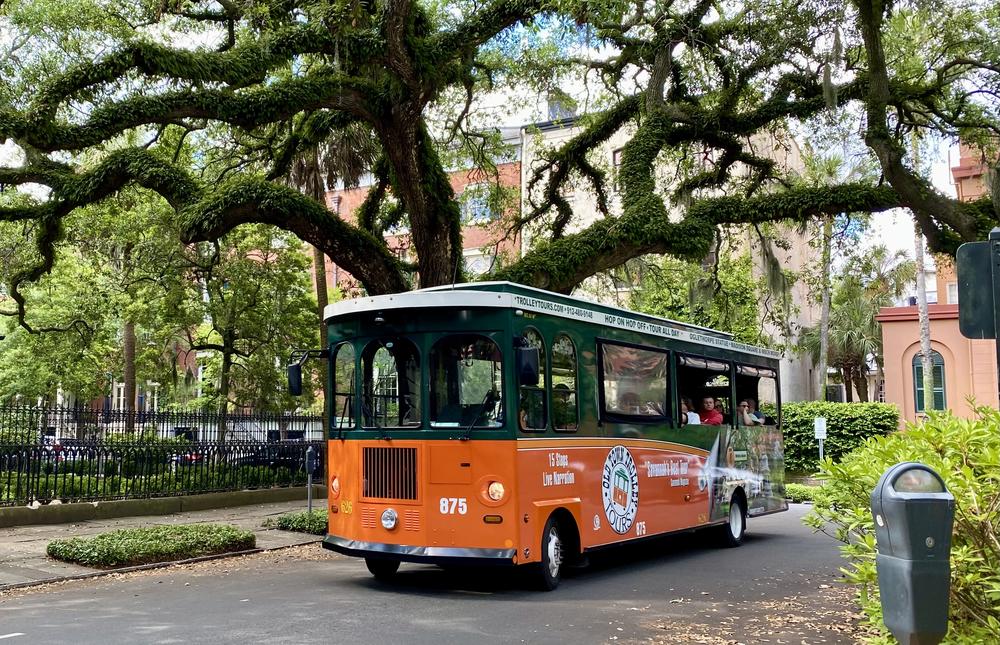 A trolley tour bus passes by Madison Square in downtown Savannah.