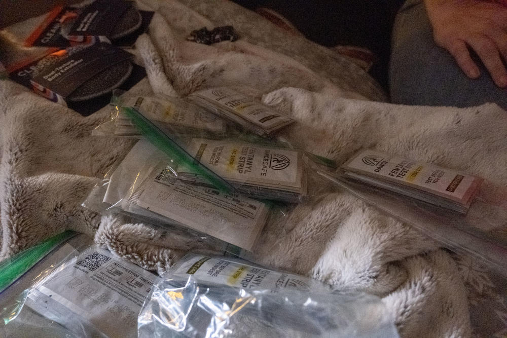A pile of fentanyl test strips, used to detect the presence of fentanyl in injectible drugs, sits on a motel room bed in Augusta.