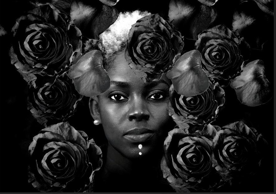A black and white photograph of a woman's face surrounded by flowers