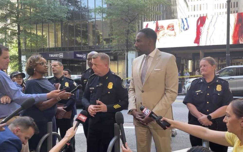 Atlanta Mayor Andre Dickens and police officials are shown speaking to reporters in downtown Atlanta.