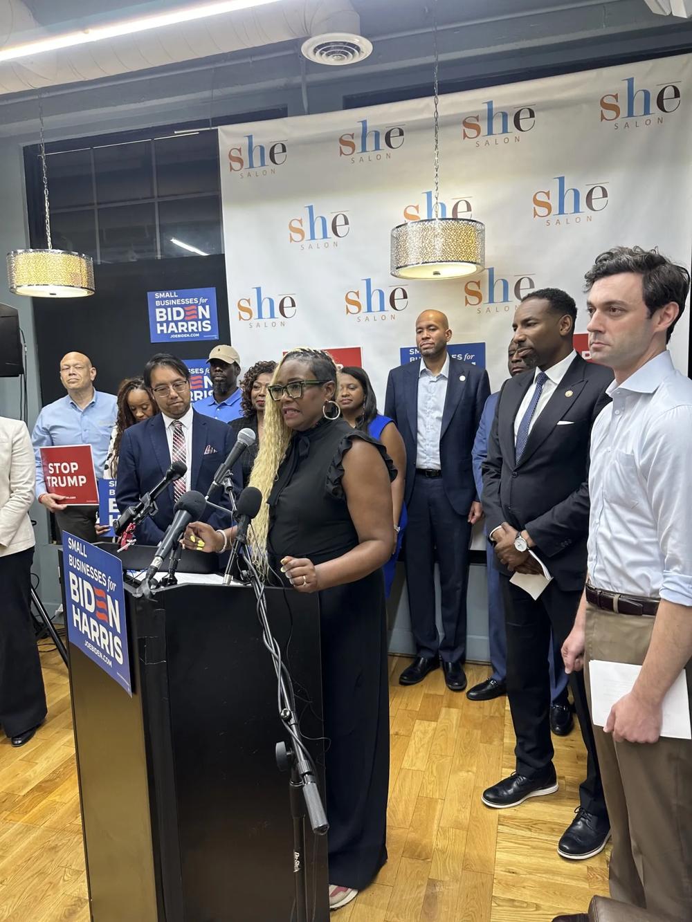 Gina Palmer, owner of She Salon, is flanked by Senator Jon Ossoff (right) and Atlanta Mayor Andre Dickens, spoke of having to watch many of her friends close their small businesses during the Trump administration. “I have seen my friends close their businesses because they were struggling to get by,” Palmer said. “Because of the Biden-Harris administration we are making a comeback.” Photo by Donnell Suggs/The Atlanta Voice