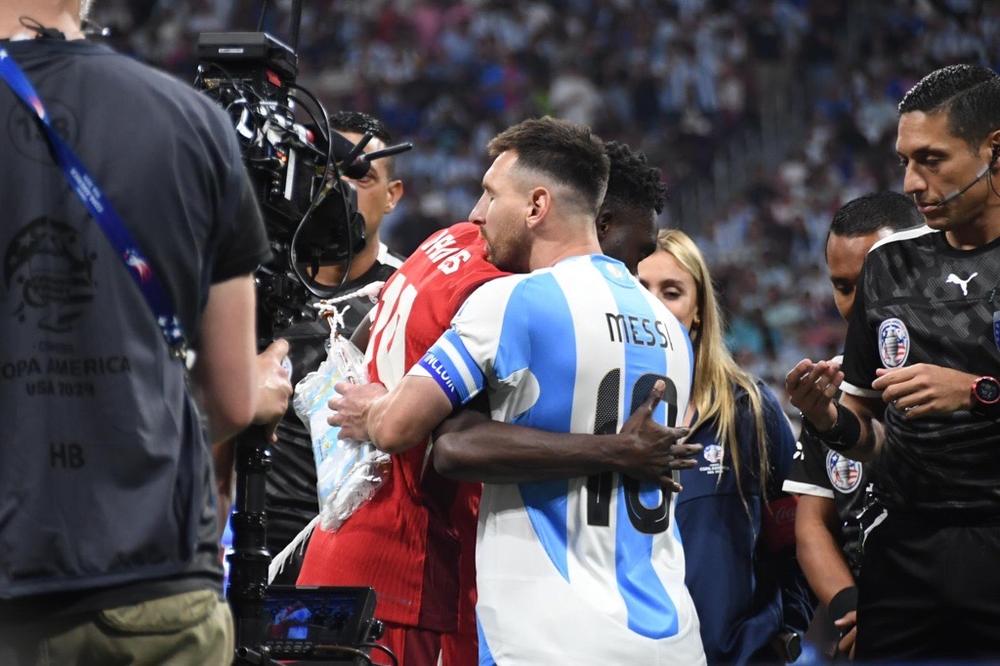 International men's soccer: Argentinian national team captain Lionel Messi (in blue) embraces Canadian national team captain Alphonoso Davies (red) at Atlanta's Mercedes-Benz Stadium on June 20, 2024. Argentina defeated Canada 2 - 0 during the first day of group stage play at Copa América 2024.
