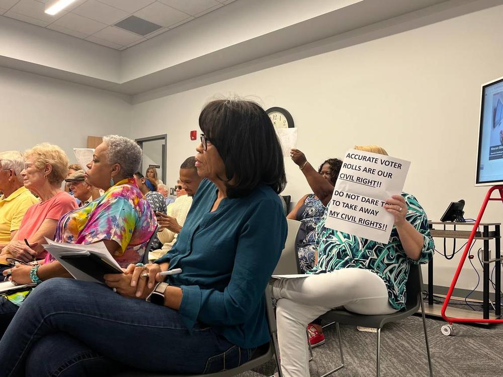 A voter held up a sign that read, “Accurate voter rolls are our civil right!! Do not dare to take away my civil rights!!” at the Macon-Bibb County Board of Elections meeting Monday, July 1, 2024. Jesse Fraga