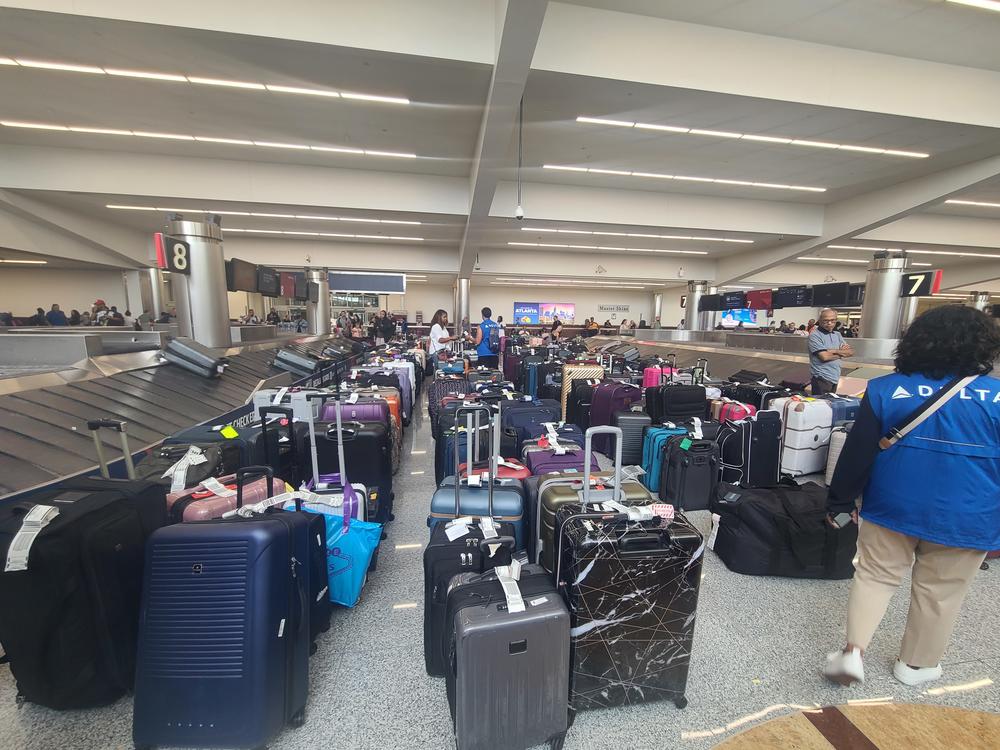Hundreds of suitcases are lined up near baggage claim at the airport in long lines