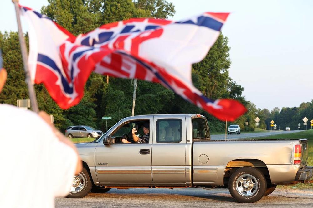 A man records the group of Trump supporters out of his truck on the side of Eisenhower Parkway on Monday, July 15, 2024, in Lizella, Georgia. A half dozen supporters, including members of the Bibb County Republican Party, gathered to show their support for former president Trump two days after an attempted assassination attempt on him in Pennsylvania. Katie Tucker/The Telegraph