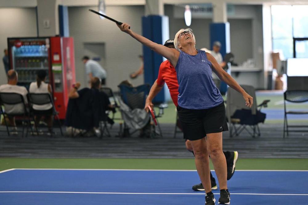Betsey Lieberman, 72, from Tallahassee, Florida, reaches for the ball during a mixed doubles match on the second day of the United States Senior Pickleball Indoor National Championships on Saturday, July 13, 2024, at Rhythm and Rally Sports & Events in Macon, Georgia. United States Senior Pickleball hosted its inaugural indoor national championships this year, spanning three days and bringing hundreds of seniors to compete in Macon from across the country. Katie Tucker/The Telegraph