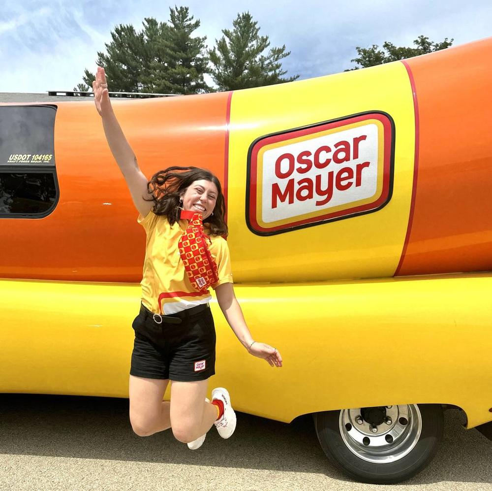 Columbus native Sarah Oney, one of 12 Wienermobile drivers Oscar Mayer selected for the 2024-25 season from more than 7,000 applications, jumps for joy during a practice event June 2024 in Darlington, Wisconsin. Jim Bria Courtesy of Sarah Oney