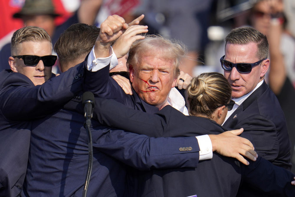 Republican presidential candidate former President Donald Trump pumps his fist as he is helped off the stage at a campaign event in Butler, Pa., on Saturday, July 13, 2024. 