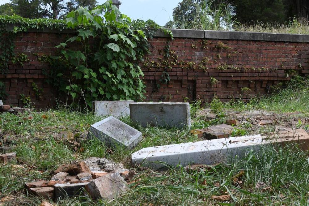 Headstones from the Woolfolk family sit overturned in the Rose Hill Cemetery on Wednesday, July 17, 2024, in Macon, Georgia. The Woolfolk family marker includes nine family members who were murdered in 1887. The area was vandalized this month. Katie Tucker/The Telegraph