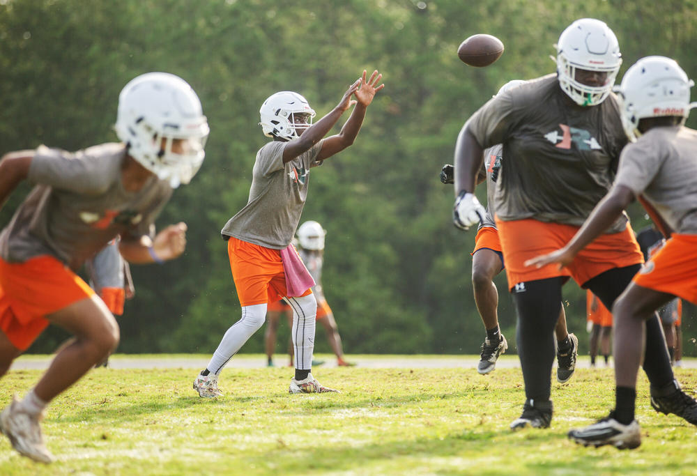 Football players in helmets only practice outside in August 2024.