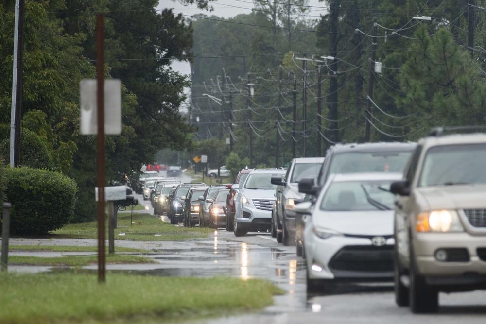 A line of at least a dozens cars is shown.