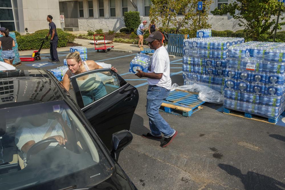 Augusta firefighters and other volunteers hand out water and ice Monday morning on the second full day without running water.