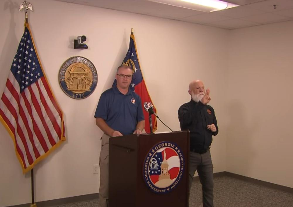 GEMA Director James C. Stallings is shown speaking behind a podium.