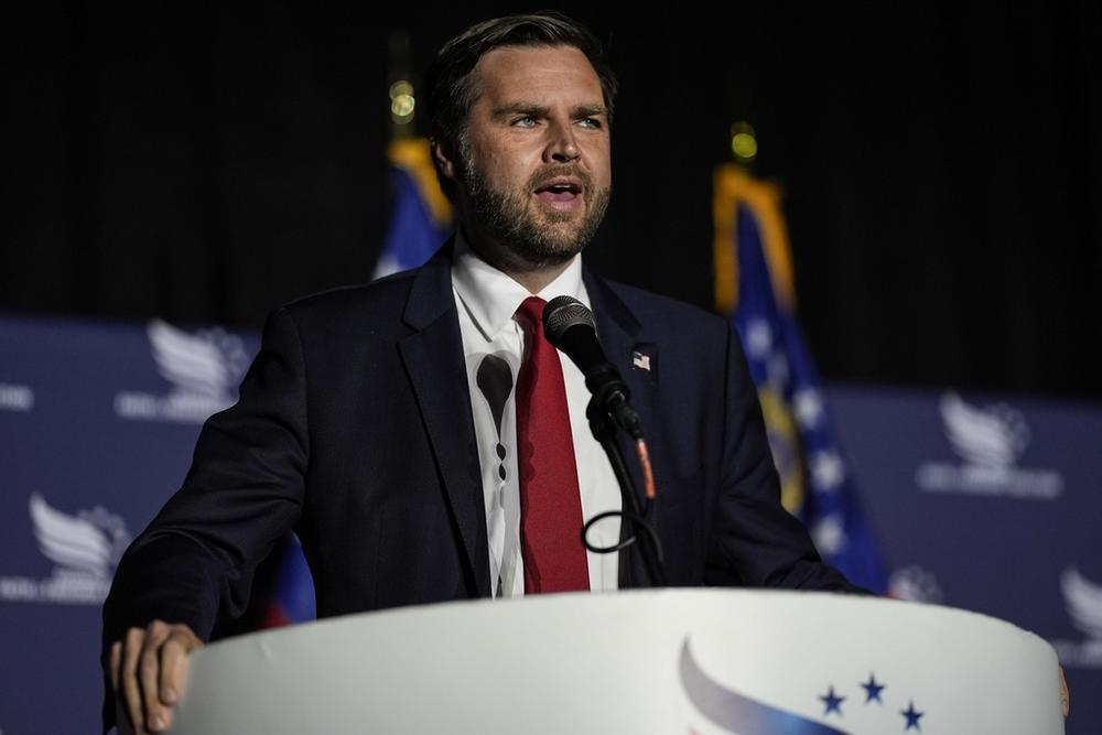 JD Vance is shown speaking at a podium.