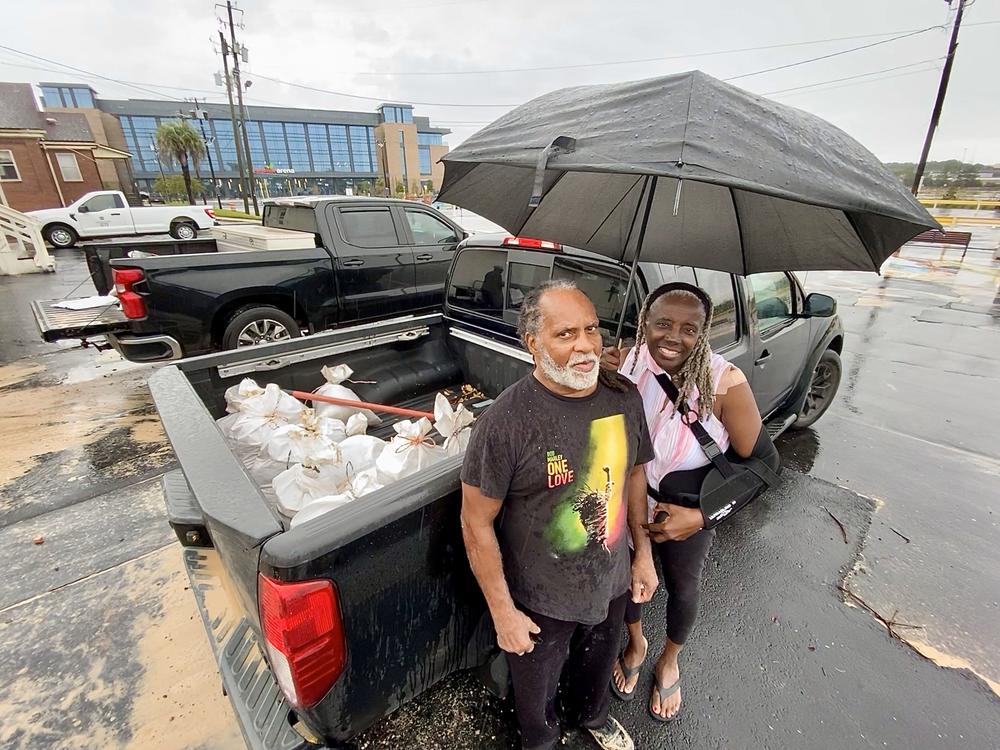 John and Deborah Thomas of Savannah stand outside their pickup truck after loading it with sandbags provided by the city in the parking lot of Enmarket Arena on Thursday, Sept. 26, 2024, in anticipation of Hurricane Helene.