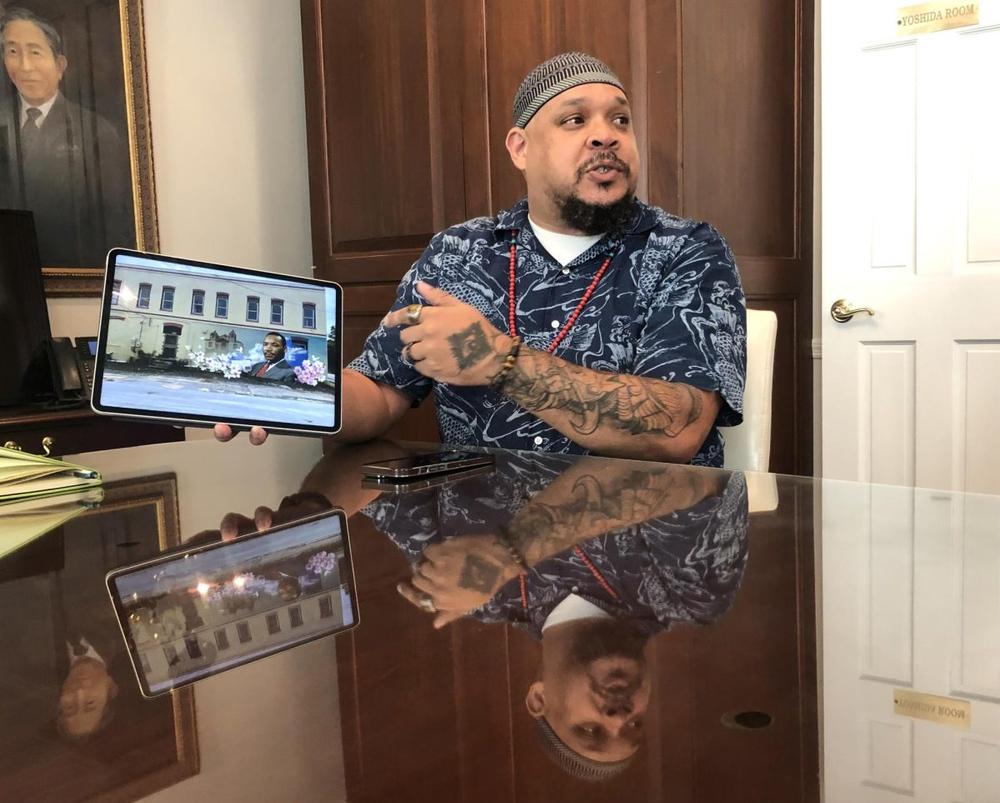 Muralist Kevin “Scene” Lewis shows a Keep Macon-Bibb Beautiful committee his plan for a Martin Luther King Jr. Mural in the 1400 block of MLK Jr. Blvd. near Downtown Macon. Liz Fabian/ Macon Newsroom