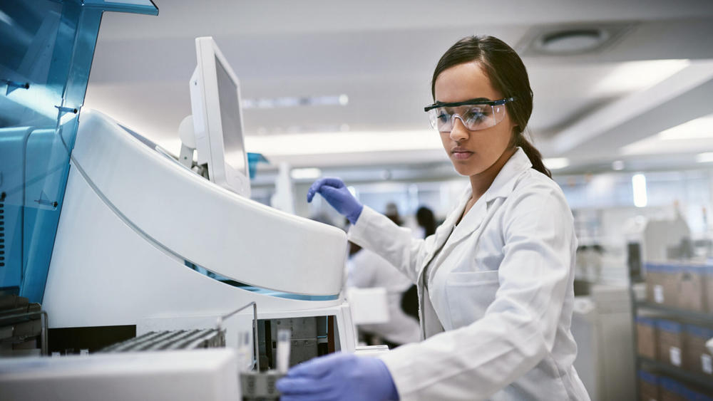 woman wearing goggles and gloves in a science lab