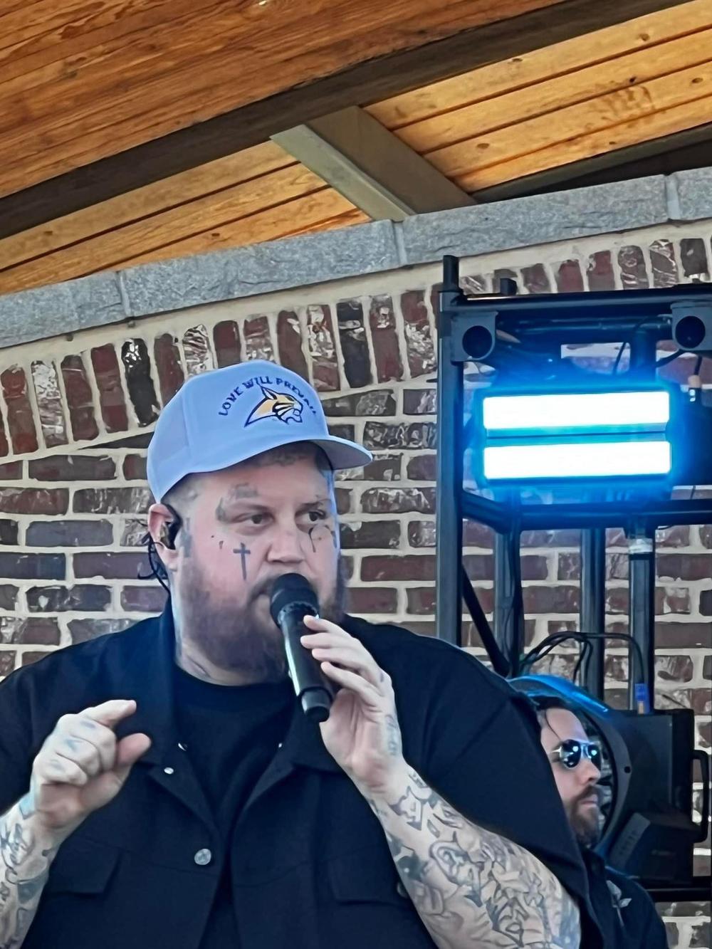 Jelly Roll wears a hat emblazoned with the Apalachee Wildcat mascot and the phrase "Love will prevail" at Jug Tavern Park on Oct. 26, 2024.