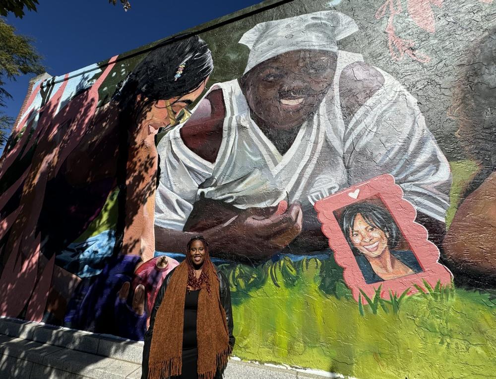 Danae Antoine, who is an Atlanta-based artist, poses for a photo they designed and painted memorializing two Georgia women who died trying to have an abortion. Jill Nolin/Georgia Recorder