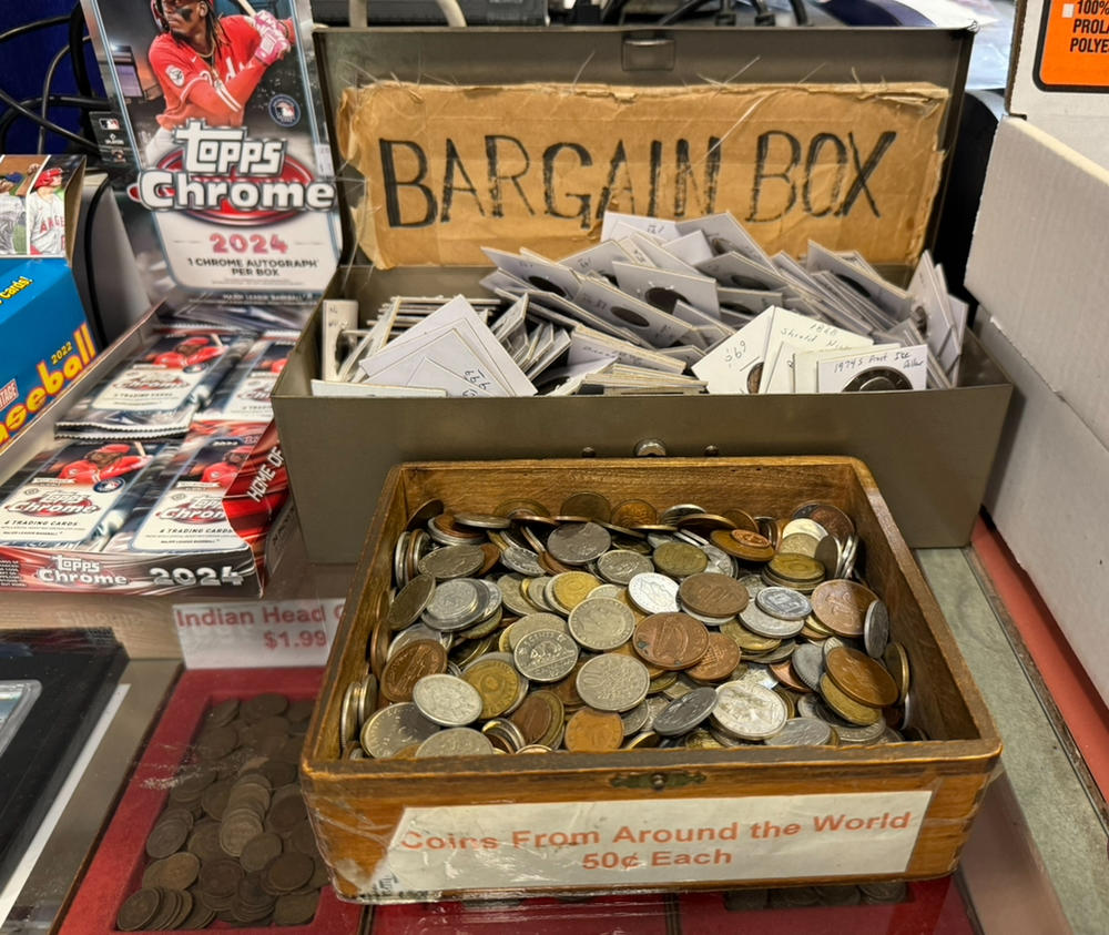 A box showcasing coins from around the world for sale inside 'Stamp & Coin.'