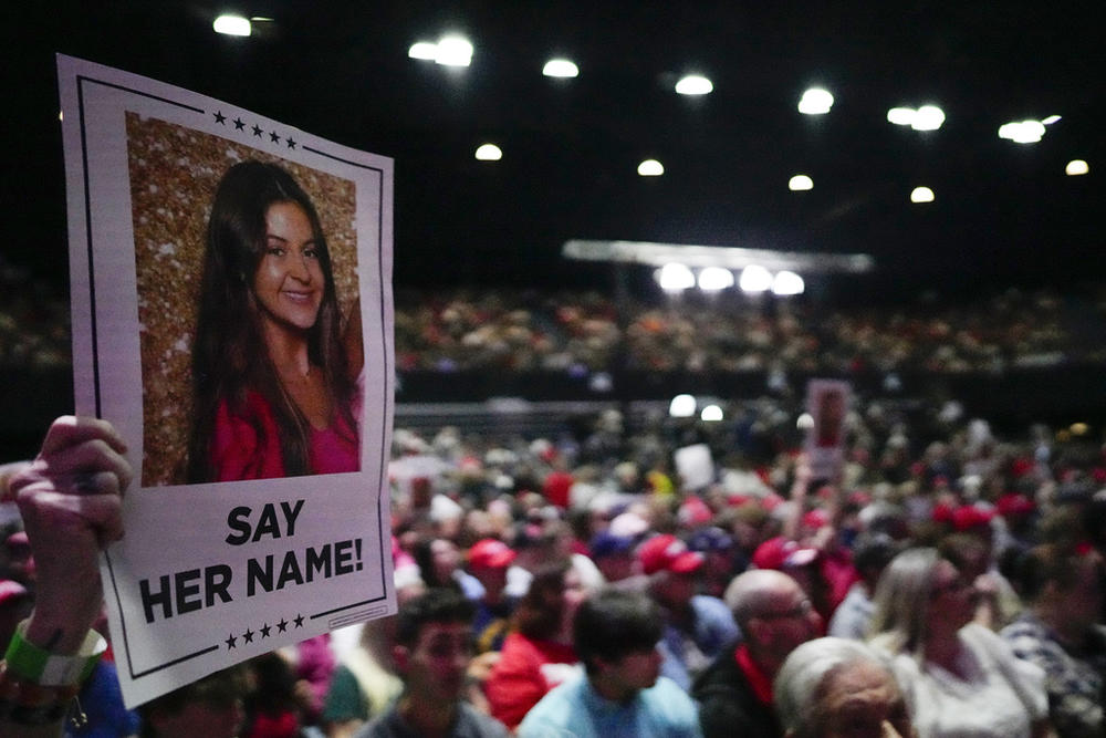 A supporter holds a sign with a photo of Laken Riley before Republican presidential candidate former President Donald Trump speaks at a campaign rally, Saturday, March 9, 2024, in Rome, Ga. 