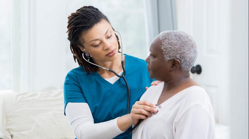 a health care provider listens to a patient's lung