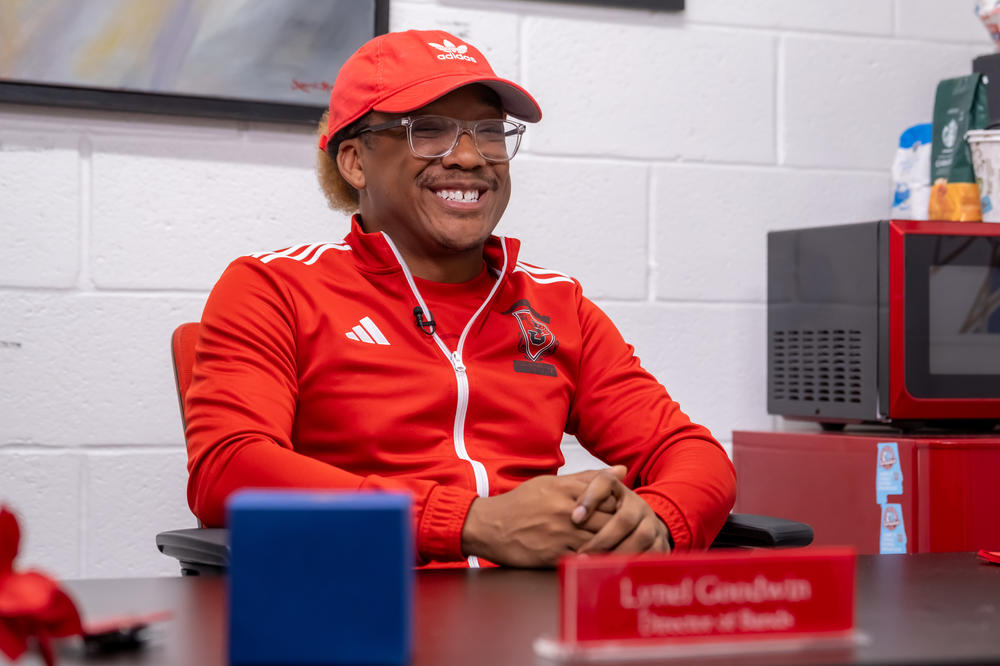 Lynel Goodwin, Band Director for the Jonesboro High Majestic Marching Cardinals, sits at his desk.