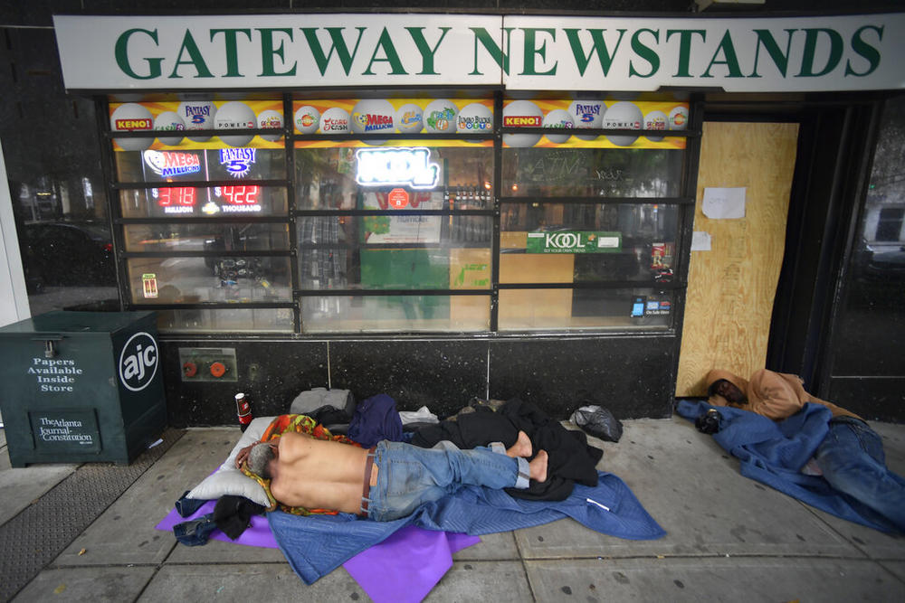 Homeless men sleep on Marietta street Friday, June 5, 2020, in Atlanta.