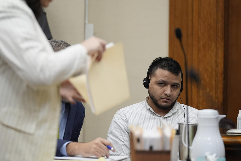 Defense attorneys Kaitlyn Beck shuffles papers in a folder as Jose Ibarra, center, accused of killing a nursing student, Laken Hope Riley, appears in court for a motion hearing on Friday, Oct. 11, 2024, in Athens, Ga. 