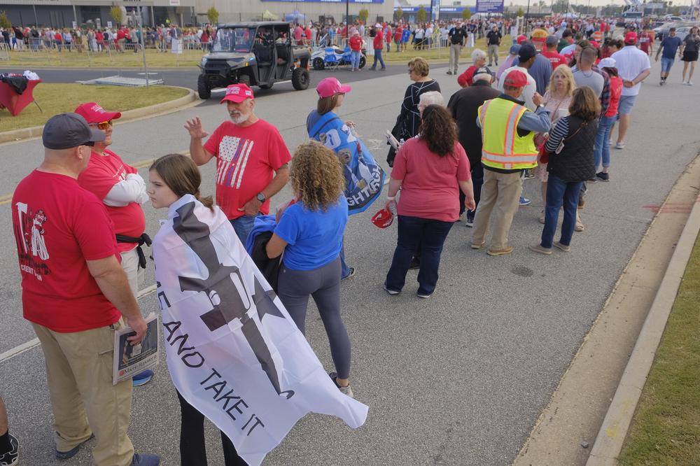 Caroline Hall 14, of Smarr, Ga. waits with her father Chris to enter the final Trump rally in Georgia in Macon Sunday. " 'Oh my gosh, we have to go,' " Caroline remembers telling her dad when she heard about the rally. "It's always been my dream to come to  see Trump."