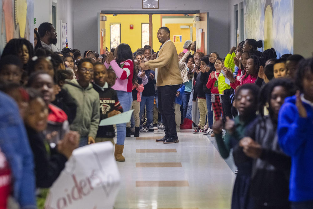 Students at Macon’s Burnell Hunt Elementary crowd the halls to see the Northeast High School Raiders football team as they walk the halls Monday. Instead of a pep rally at home, the Raiders visited the schools most of them attended years ago ahead of their Tuesday GHSA championship game. 