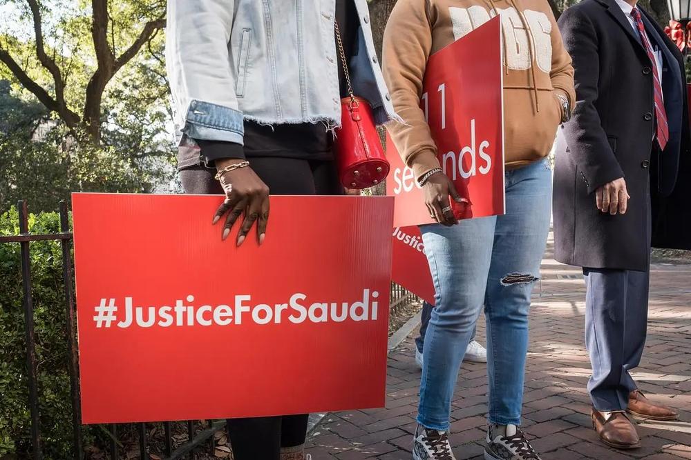 Attendees hold signs in support of the Lee family as William Claiborne, attorney for the family of Saudi Lee, speaks at a press conference, on December 4, 2024, in Savannah, GA. (Justin Taylor/The Current GA)