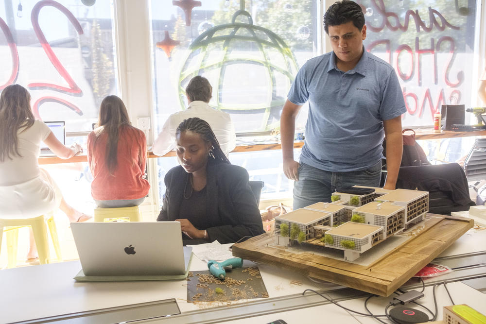 Kennesaw State University student Justin Monzon, right, examines the model mixed use development he and fellow student Soreya Ganda, center, designed for Macon’s Greenwood Bottom, called the Hive, before their final project presentation recently. 