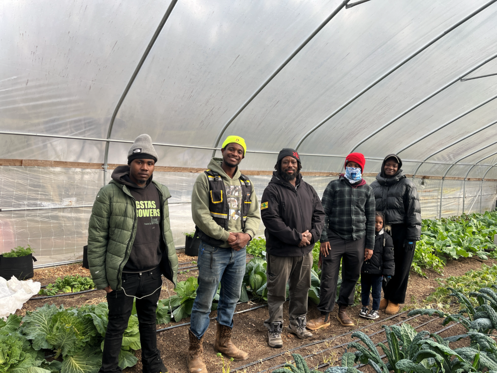 Participants in Gangstas to Growers stand in the greenhouse at Phoenix Garden in Lawrenceville, GA. 