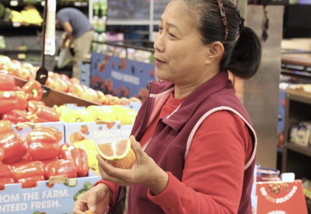 Inside a Kroger grocery store in Bonaire, Ga., Jocelyn Clark tries fresh citrus products from Lindy Savelle's JoNina Farm.