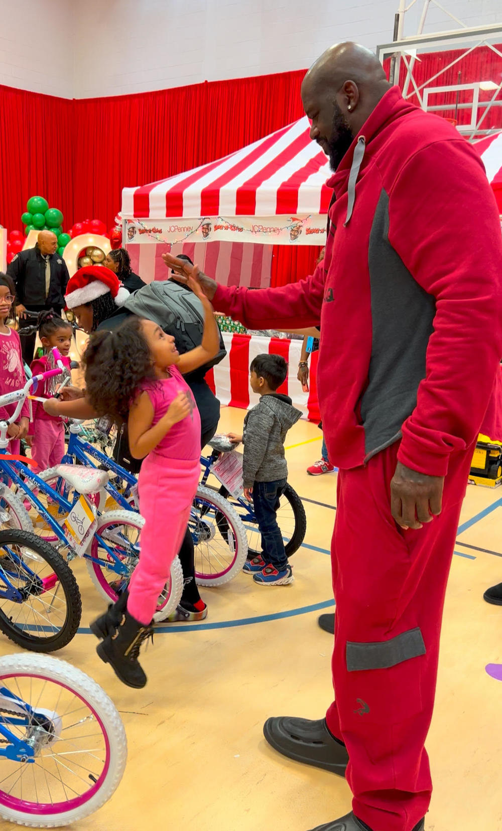 Shaquille O'Neal gives a student a high five at this annual Shaq-a-Claus event