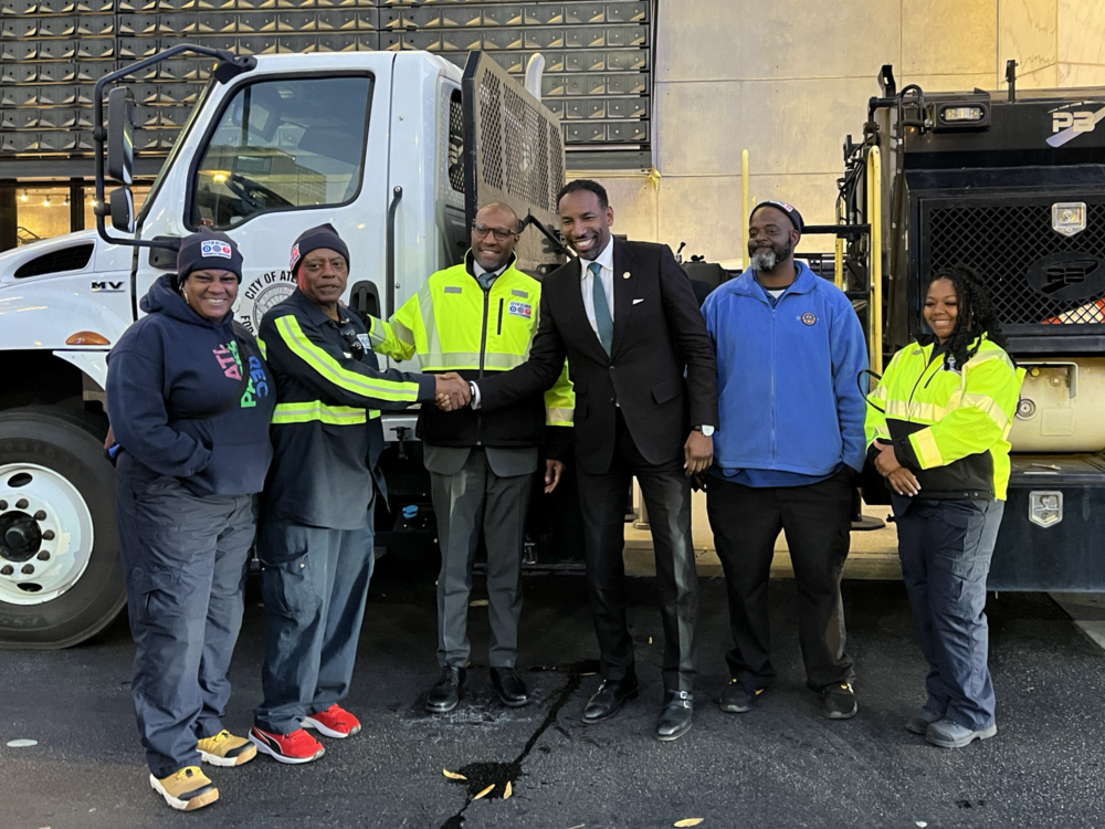 Atlanta Mayor Andre Dickens and ATLDOT Commissioner Solomon Caviness join workers in front of a brine truck on Dec 12, 2024.