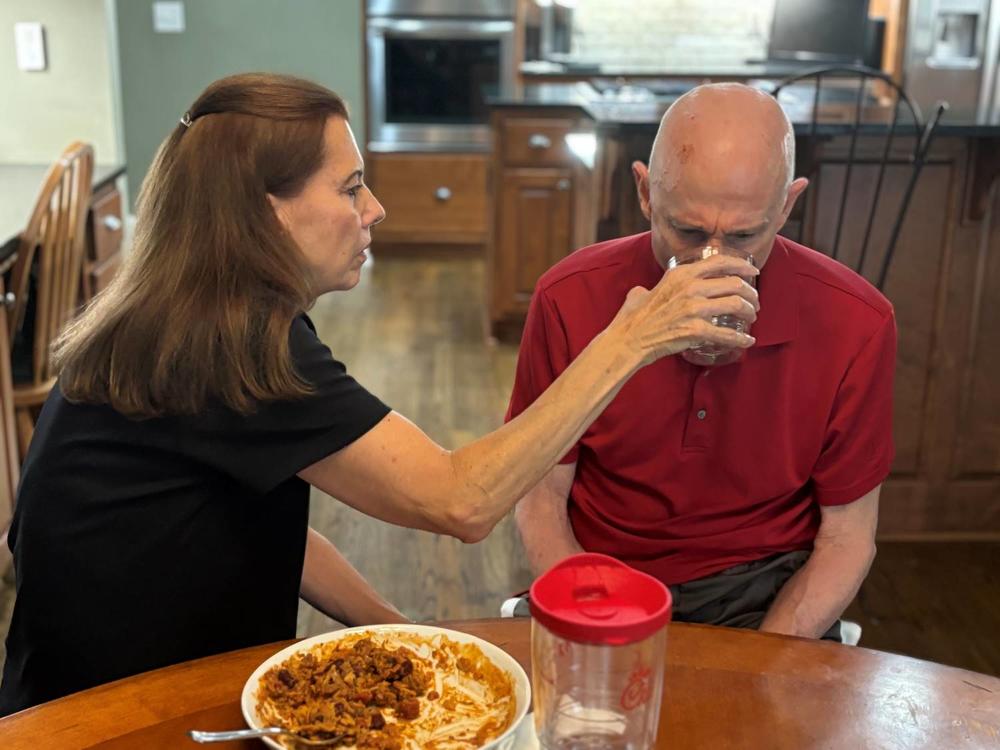 Nancy Treaster helps her husband, Kim Treaster, eat lunch.