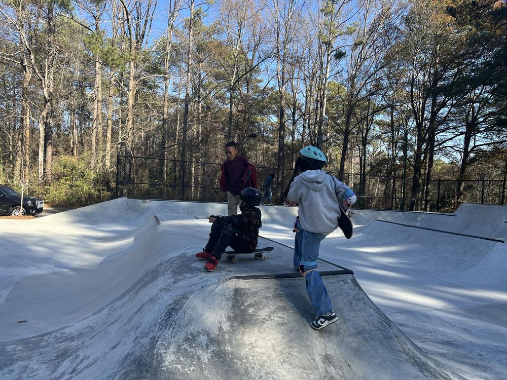 Gabriella (blue helmet) and Kymanii (black helmet) prepare to skate down the new ramps.