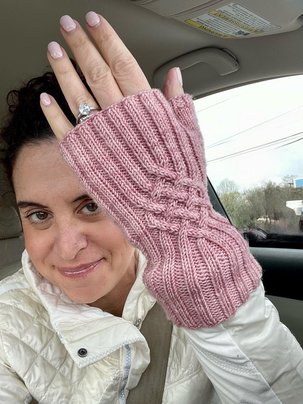 Woman displaying a pink knitted mitt