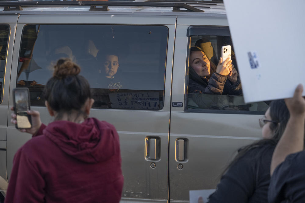 Drivers pass by a protest against President Trump's immigration policy on a main thoroughfare in Gainesville, Ga., on Jan. 29, 2025.