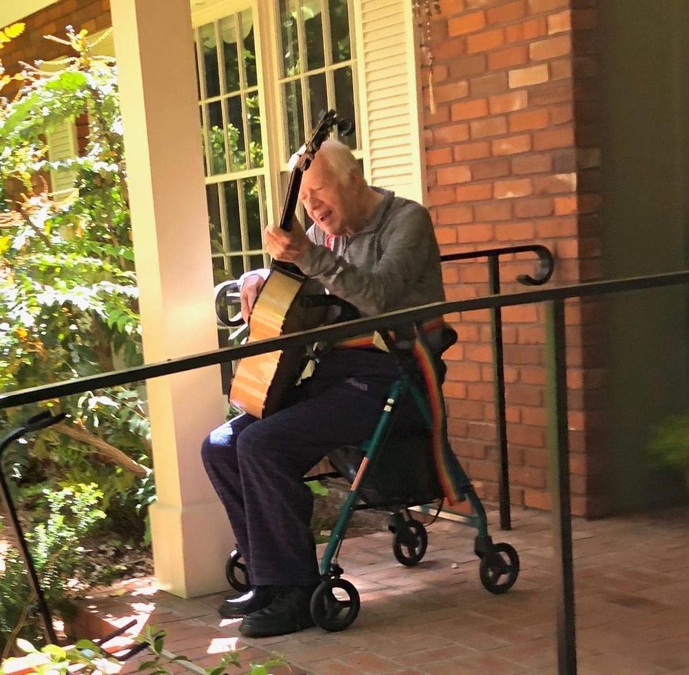 Former President Jimmy Carter plays his custom made Kostal guitar outside his home in Plains, Ga.