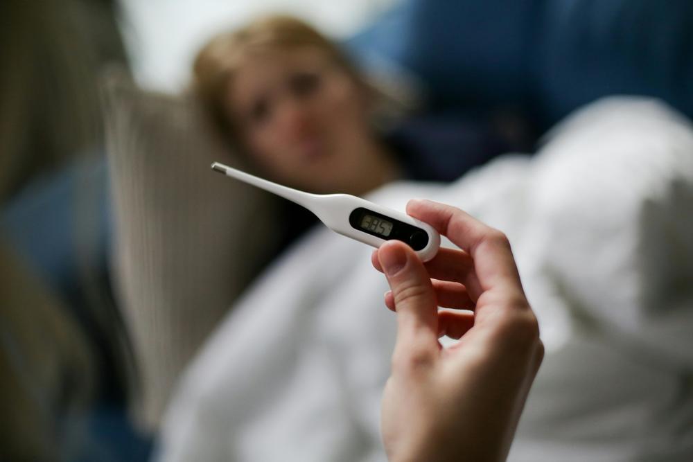 A Person Holding a Thermometer. Pexels