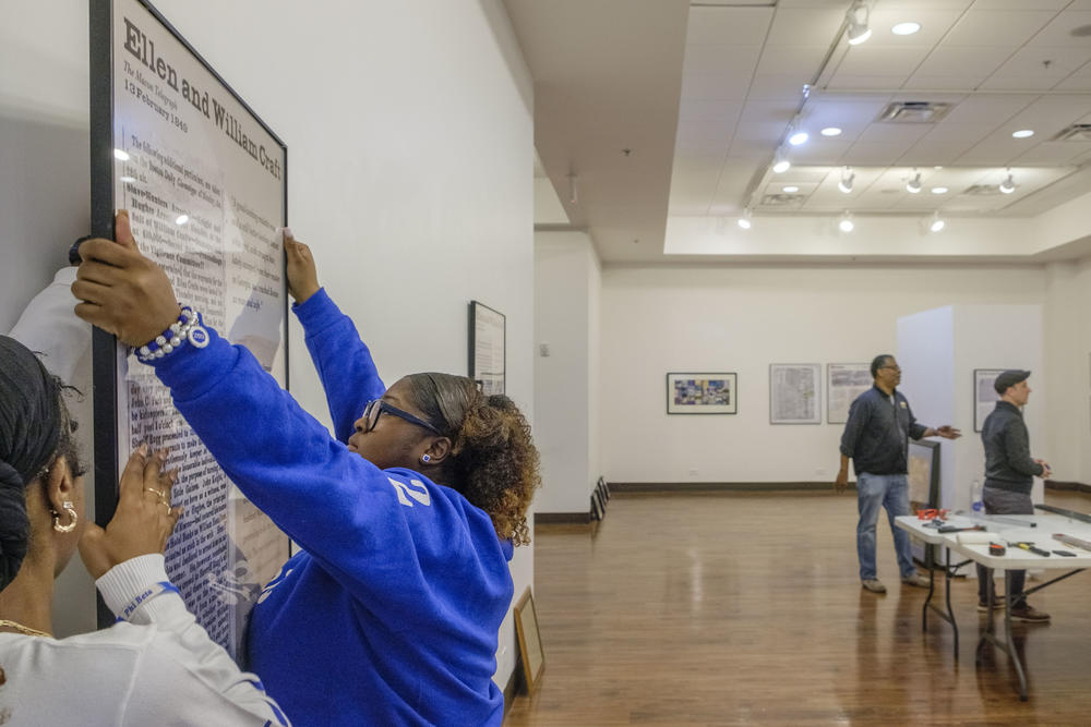 Mercer University sophomore Taylor Boyd mounts a piece of the Freedom Seekers exhibit at Tubman African American Museum in Macon. The exhibit features so-called “runaway slave ads” researched by students like Boyd. “They had everyday problems just like us,” Boyd said. “Reading their stories and reading that they were running away to families or they had lovers that really just exemplified the importance of why we need to showcase this.”